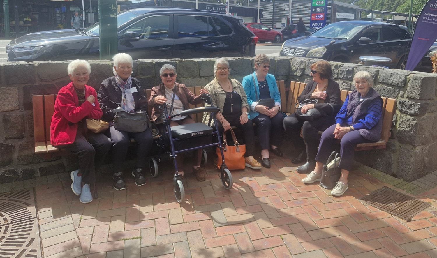 A group of guests resting on a sunny bench