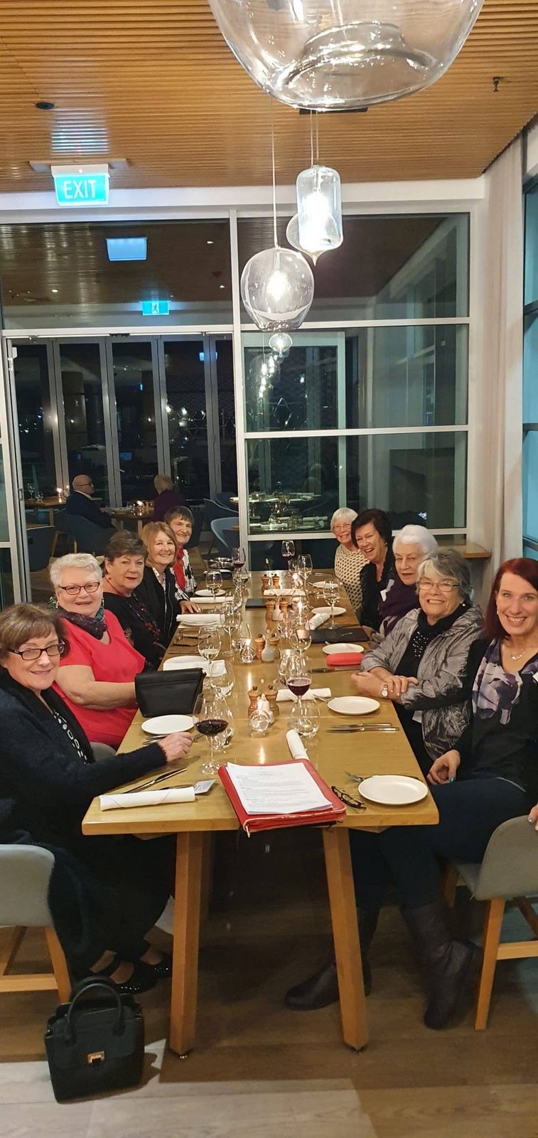 Guests sharing dinner at a long restaurant table