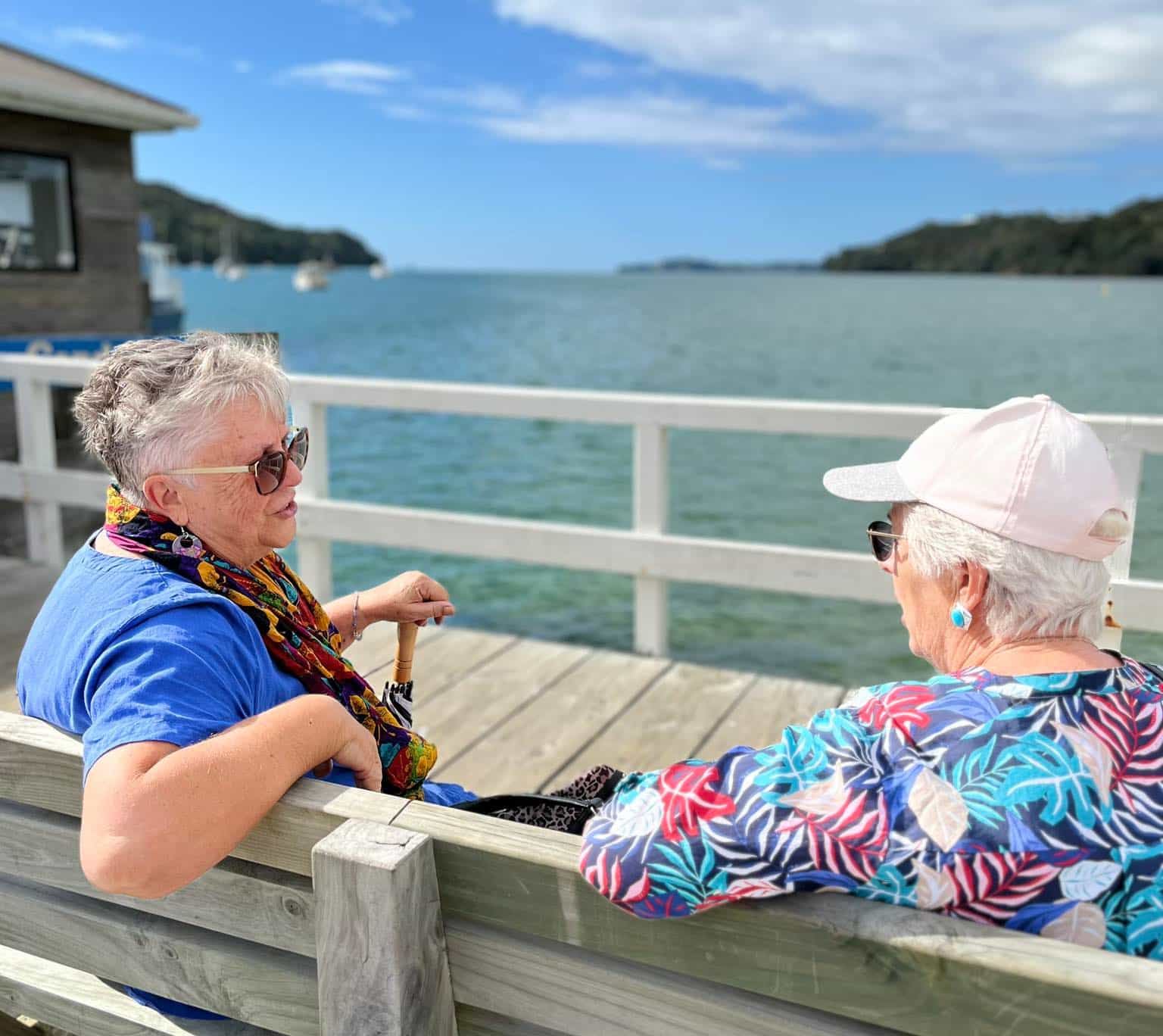 Two friends chatting on a sunny wharf