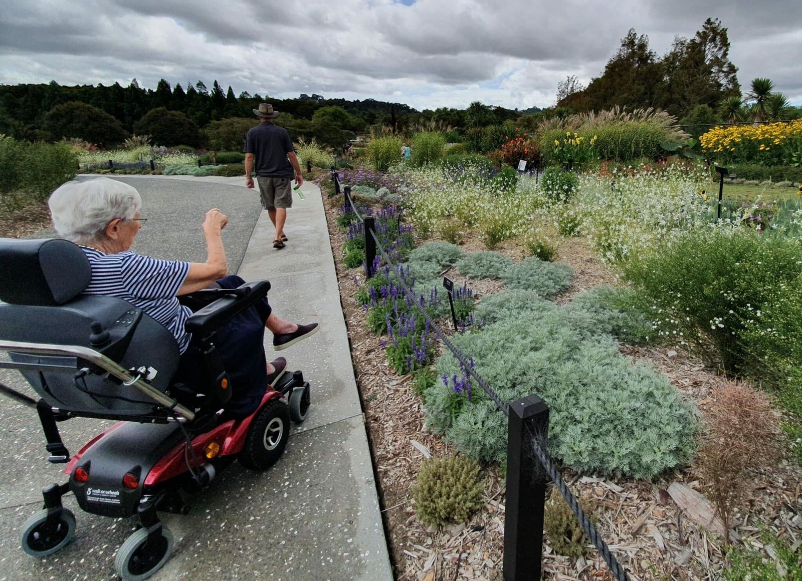 A guest in a mobility scooter enjoying a garden path