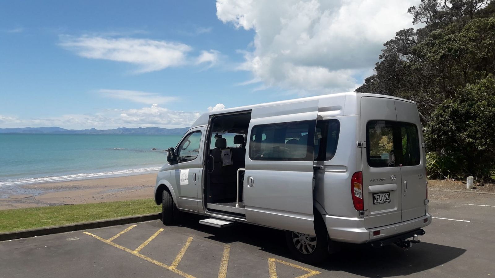 The silver Silver Rose Tours van parked by the beach