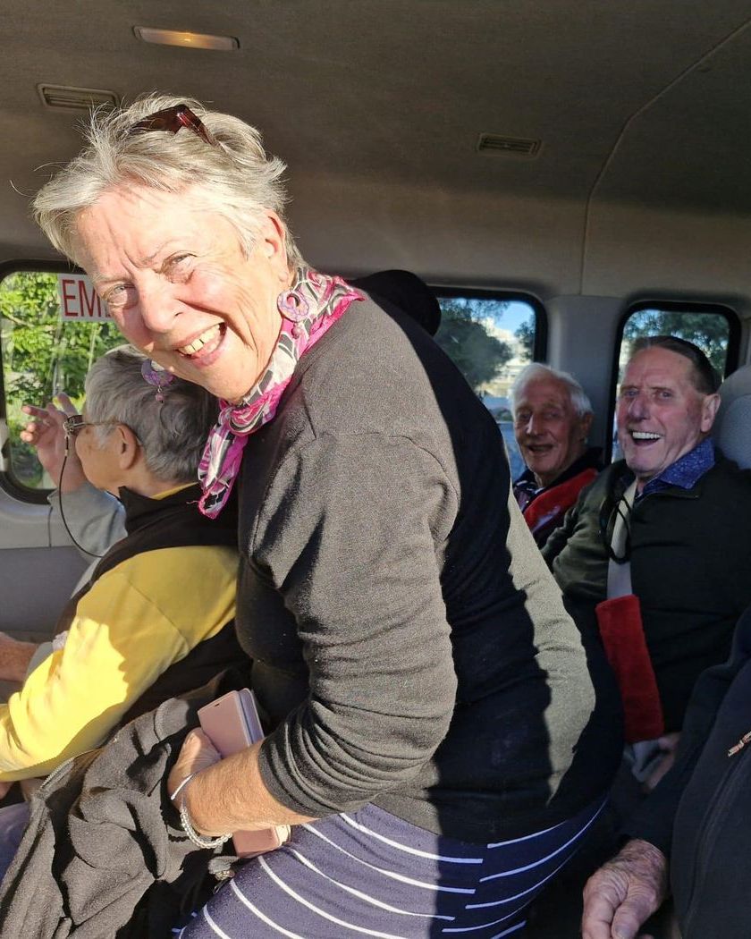 Guests laughing together in the Silver Rose van on the way to a day out