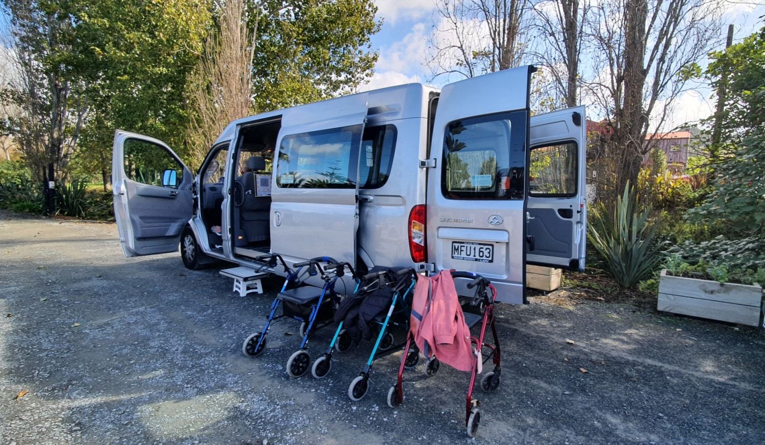 The van with doors open and walkers lined up beside it